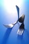 Two forks bent on blue background