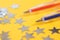 Two fountain pens: blue and red lie next to the silver stars on a yellow background. The system of performance and grades in