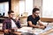 Two freelancer men working at laptop and drinking coffee at desk.