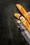 Two french baguettes on black chalkboard from above