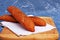 Two fresh baguettes lie on a towel on a wooden background