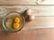 Two fresh chicken yolk and egg white in clear glass cup and another two eggs beside it on rubber wood table