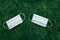 Two fresh new sanitary masks lying on grass ground. Disposable recyclable face mask flat lay. Coronavirus, medicine, seasonal