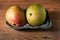 Two fresh ripen mango in a grey container on a wooden table surface, Fresh fruit industry concept