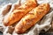 Two Freshly Baked Baguettes Lying Side by Side on a Textured Cloth