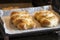 two freshly baked easter braids on a baking sheet in the oven