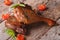 Two fried duck legs and basil, cherry tomatoes closeup on table