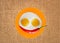 Two fried eggs and red hot chilly pepper on orange plate, knife