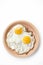 Two fried eggs in reddish yellow plate