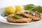 Two fried fish fillet from the flatfish flounder with potatoes, spinach and flat leaf parsley. Close up image with selective focus