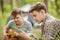 Two friend sitting in the tent, playing guitar and reading