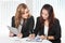 Two friendly businesswomen sitting and discussing new ideas