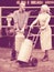 Two friendly farmers holding a trolley with milk