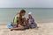 Two friendly girls sisters relax on a sandy beach on a hot summer