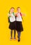 Two friendly schoolgirls in uniform are holding fingers up