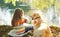 Two friends, child with Labrador retriever dog sitting in summer