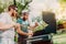 Two friends cooking on grill during summertime. Portrait of men grilling and having a garden barbecue party