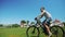 Two friends on cycle ride on green grass field together