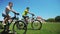 Two friends on cycle ride on green grass field together