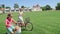 Two friends on cycle ride on green grass field together