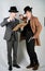 Two friends dressed in vintage clothes and depict retro detectives and spies in English classic style on a white studio background