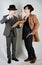 Two friends dressed in vintage clothes and depict retro detectives and spies in English classic style on a white studio background