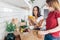 Two friends in the kitchen prepare salad and eat corn.