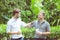 Two friends men talking standing in a garden.