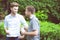 Two friends men talking standing in a garden.