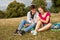 Two friends in a park with mobile phone. Summer time.