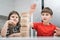 Two friends playing board game Jenga, building tower made of wooden blocks. Schoolboy raising hand placing detail.