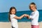 Two friends playing hand game on beach.