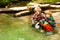 Two friends playing with paper boats at river bank