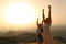 Two friends raising arms celebrating at sunset