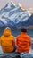 Two friends savoring the stunning view of majestic mountains at an alpine lake, seated on the edge