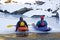 Two Friends Sitting on Ice In Colorful Kayaks