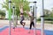 Two friends swinging in a monkey bar at a calisthenics park wearing protective face masks