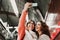 Two friends waiting going down stairs at the station before catching a train. Taking selfie with mobile phone. Travel photography