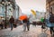 Two friends walk in the city center under bright umbrellas in the autumn or spring season. Friendship concept, off-season, travel