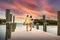 Two friends walking along a ocean pier together watching a beautiful picturesque sunset while on vacation
