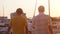 Two friends are walking at the promenade. Beautiful golden sunset at the yachts beach and lens flarre effect. slow