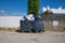 Two full garbage containers in street