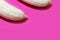 Two fully peeled bananas on a pink background top view close-up. Flat lay with copy space for text