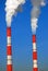 Two fuming tubes of red and white colors. Blue sky background.