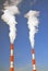 Two fuming tubes of red and white colors. Blue sky background.