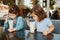 Two funny Caucasian preschool sisters siblings drink sip milk shakes in a cafe. Friends girls eating brunch breakfast outdoor.