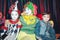 Two funny clowns are photographed with a boy.