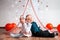 Two funny little babies pose on a white background decorated with hearts and balloons. Valentine`s day concept