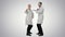 Two funny medical doctors with funny energy dance on white background.