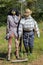 Two funny scarecrows in the field. Pair of scarecrows with hat and stick. Harvest protection and security concept. Rural landscape